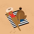 A couple lies on the beach on a striped plaid